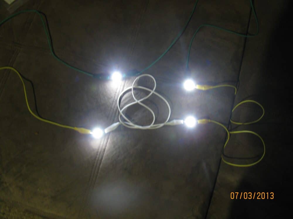 joule thief prototype showing the working of illuminated 4 nos of 1 watt LEDs in darkness using a 1.5V battery